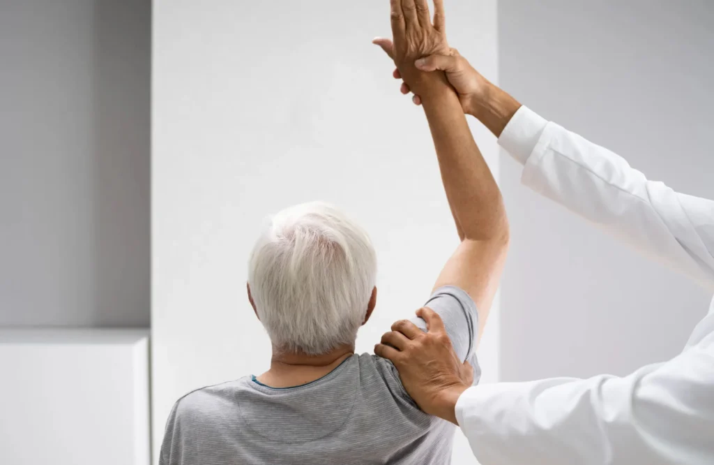 Physiotherapist assisting an elderly patient with arm exercise during Cardiac Rehabilitation Banjara Hills.
