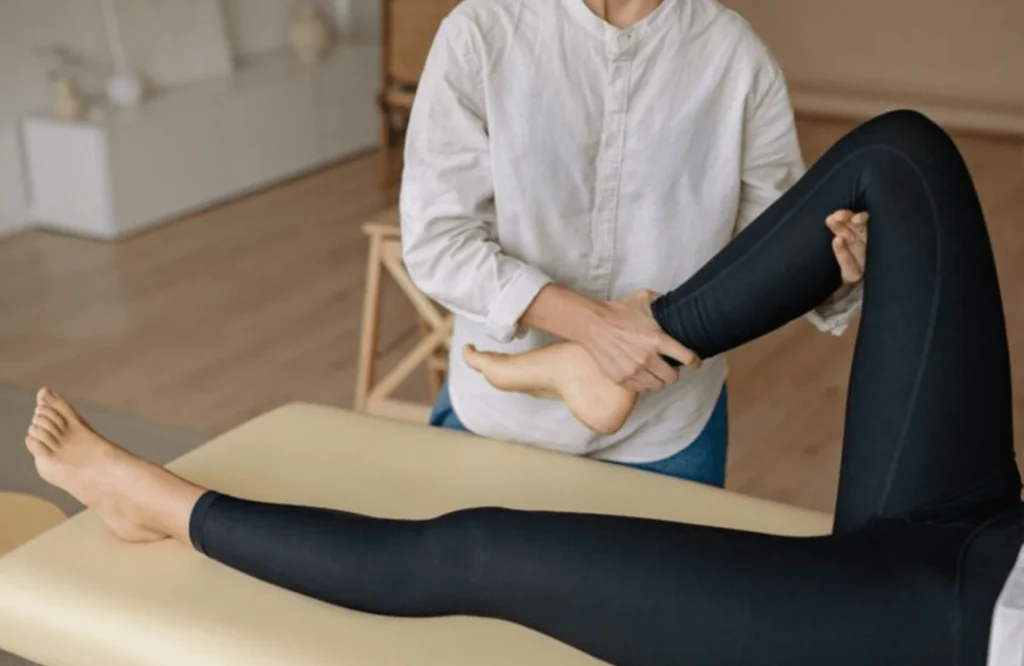 Therapist assisting a patient with guided arm movement during a physiotherapy session, illustrating hands-on treatment and rehabilitation care.